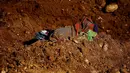 Tampak pakaian para korban longsor yang berada direruntuhan pasir selama pencarian korban di lokasi tambang Hpakant giok, Myanmar, (21/11). Diperkirakan masih ada ratusam korban yang belum ditemukan. (REUTERS/Stringer)