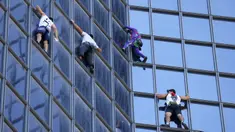 Pendaki Alain Robert (kedua kanan) atau Spiderman Prancis bersama Marcin Banot, Alexis Landot, dan Leo Urban memanjat Menara Total di La Defense, Paris, Prancis, 7 September 2021. Alain dengan tangan kosong memanjat menara setinggi 190 meter itu untuk menentang izin kesehatan. (THOMAS SAMSON/AFP)