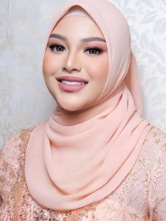 Serta hijab segi empat warna senada dengan kebayanya, ditata sederhana oleh hijab stylist, Nia. (Instagram/dhirmanputra)