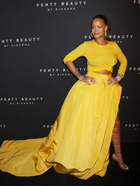 Rihanna berpose untuk fotografer setibanya pada peluncuran Fenty Beauty by Rihanna di Duggal Greenhouse, New York, Kamis (7/9). Penyanyi itu menggunakan high heels gladiator warna emas untuk menambah kesan modis. (Victor Malafronte/STAR MAX/IPx/AP Images)