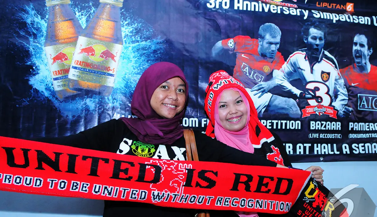 Dua Simpatisan United membentangkan slayer MU saat menghadiri acara Ulang tahun ke-3 Simpatisan United di Hall A Senayan, Jakarta, Sabtu (20/12/2014). (Liputan6.com/Faisal R Syam)