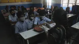 Sejumlah siswa mengenakan masker saat prose belajar mengajar di sebuah sekolah pemerintah di Hyderabad, India, Rabu (4/3/2020). Masker kini hal yang wajib digunakan siswa sejak virus corona memasuki wilayah India. (AP Photo/Mahesh Kumar A.)