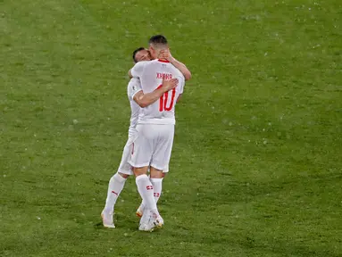 Pemain Swiss,  Xherdan Shaqiri dan Granit Xhaka merayakan kemenangan atas Serbia pada laga grup E Piala Dunia 2018 di Stadion Kaliningrad, Jumat (22/6). Selebrasi Xhaka dan Shaqiri memicu kontroversi ketika mengalahkan Serbia 2-1. (AP/Antonio Calanni)