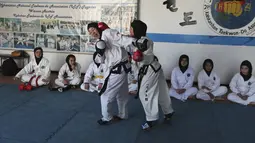 Gadis-gadis Afghanistan berlatih tanding selama sesi pelatihan taekwondo di sebuah klub swasta di Kabul, Afghanistan pada 1 Maret 2021. Latihan bela diri ini mengupayakan para perempuan di Afghanistan bisa melindungi dirinya sendiri. (AP Photo/Rahmat Gul)