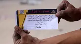 Seorang pria Palestina memegang selebaran yang dibagikan oleh tentara Israel pada 22 Mei 2025. (BASHAR TALEB/AFP)
