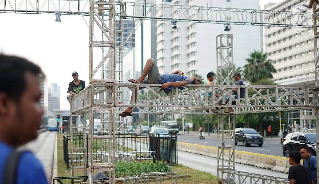 Pekerja menyelesaikan pembuatan panggung hiburan malam puncak HUT Ke-492 Kota Jakarta di Bundaran HI, Jakarta, Jumat (21/6/2019). Malam puncak HUT Jakarta dibalut dalam konsep ekonomi kreatif dan seni pada Sabtu 22 Juni. (Liputan6.com/Immanuel Antonius)