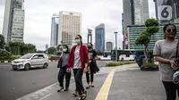 Orang-orang berjalan di trotoar kawasan Sudirman, Jakarta, Rabu (16/12/2020). Pemerintah Provinsi DKI Jakarta mendukung kebijakan Wakil Ketua Komite Penanganan Covid-19 Luhut Pandjaitan yang meminta agar kebijakan WFH diperketat. (Liputan6.com/Faizal Fanani)