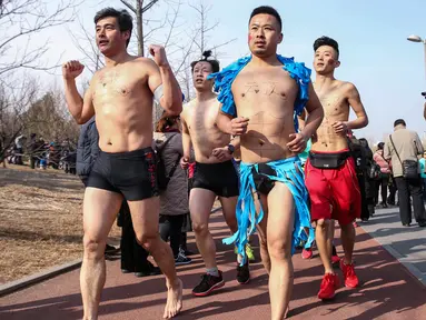 Para peserta mengambil bagian dalam lomba lari tahunan Undie Run di Olympic Forest Park, Beijing pada 24 Februari 2019. Pesertanya pun diwajibkan berlari sambil mengenakan kostum unik atau pakaian dalam saja. (Photo by STR / AFP)