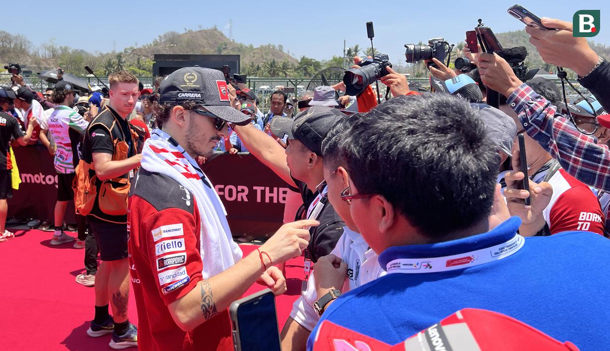 Pembalap Ducati Lenovo Team, Francesco Bagnaia (kiri), berbincang dengan penggemar yang hadir di Sirkuit Mandalika, Lombok , Minggu (15/10/2023). (Bola.com/Benediktus Gerendo Pradigdo)