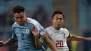 Striker Kashima Antlers, Hiroki Abe berusaha merebut bola dari pemain Uruguay Jose Maria Gimenez selama pertandingan Copa America di Stadion Gremio Arena di Porto Alegre, Brasil pada 20 Juni 2019. Abe merupakan pemain muda terbaik J-League pada 2018. (AFP Photo/Carl De Souza)