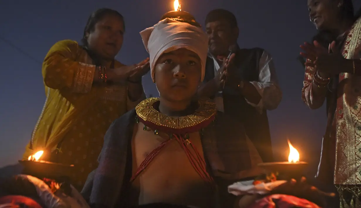 Seorang umat Hindu membawa lampu minyak selama perayaan pada hari kesepuluh festival Dashain di sebuah kuil di Bhaktapur di pinggiran Kathmandu, Nepal (15/10/2021). (AFP/Prakash Mathema)