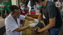 Petugas menyuntikkan vaksin rabies pada seekor kucing peliharaan warga di kantor kelurahan Petukangan Selatan, Jakarta, Rabu (15/9/2021). Dinas Ketahanan Pangan dan Pertanian memberikan vaksinasi rabies bagi hewan peliharaan milik warga untuk mengantisipasi penyakit rabies. (Liputan6.com/Faizal Fana