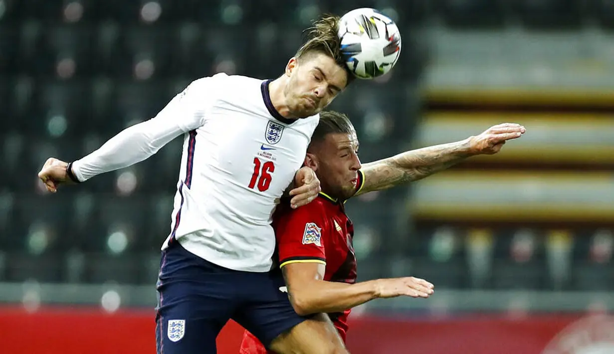 Pemain Inggris, Jack Grealish, duel udara dengan pemain  Belgia, Toby Alderweireld, pada laga UEFA Nations League di Stadion King Power, Senin (16/11/2020). Belgia menang dengan skor 2-0. (AP/Francisco Seco)