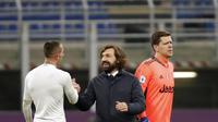 Pelatih Juventus, Andrea Pirlo (tengah) tersenyum dengan Federico Bernardeschi usai pertandingan lanjutan Liga Serie A Italia melawan AC Milan di stadion San Siro, Rabu (7/1/2021). Rekor tak terkalahkan AC Milan patah. Rossoneri takluk 1-3 dari Juventus. (AP Photo/Antonio Calanni)