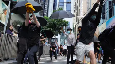 Para pengunjuk rasa menggunakan ketapel mencoba menembak saat demonstrasi di Hong Kong (11/11/2019). Ketapel hingga panahan digunakan para demonstran Hong Kong sebagai senjata saat unjuk rasa yang telah berlangsung selama lima bulan. (AP Photo/Vincent Yu)