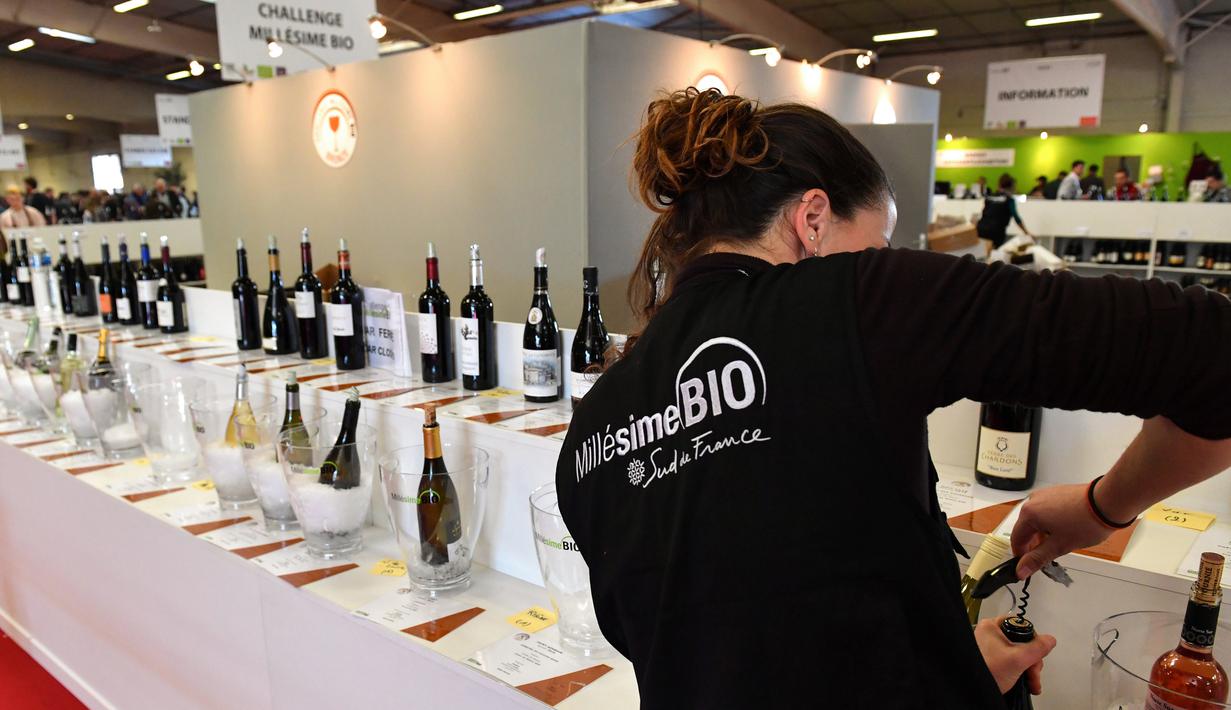 Pengunjung membuka botol wine organik dalam acara Millesime Bio 2018 di Kota Montpellier, Prancis, Senin (29/1). (AFP PHOTO/PASCAL GUYOT)