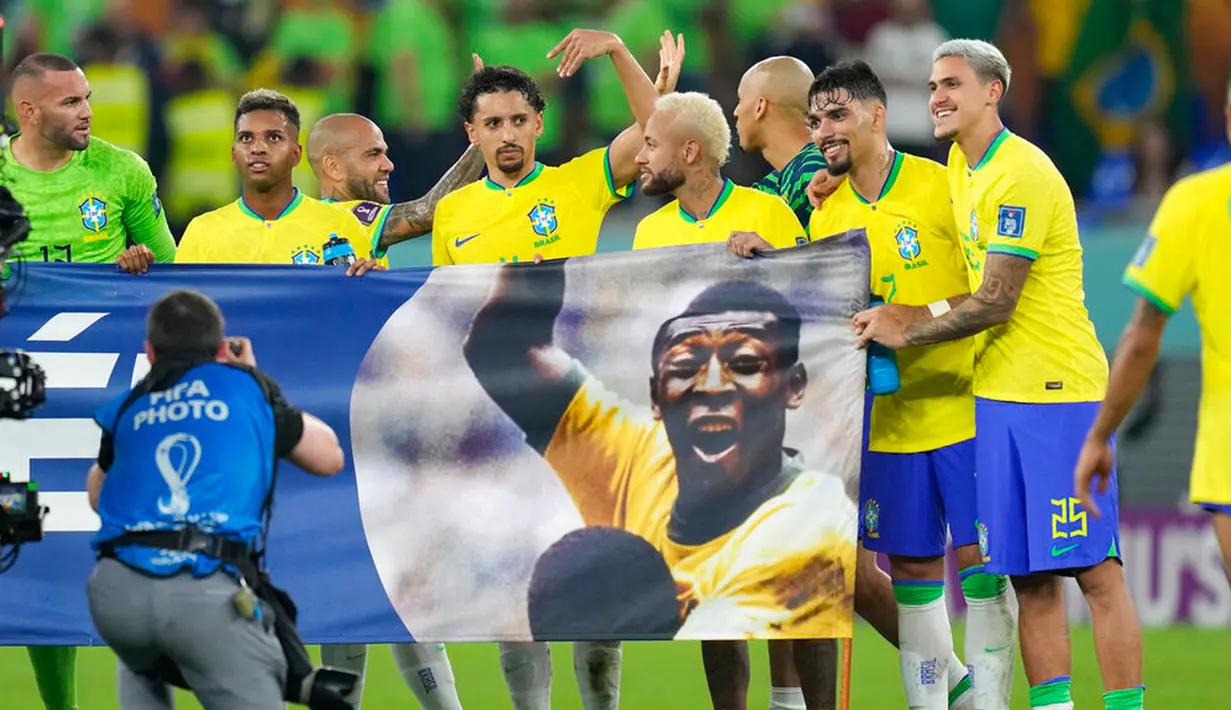 Para pemain Brasil membentangkan spanduk dukungan untuk Pele yang sedang sakit pada akhir pertandingan sepak bola babak 16 besar Piala Dunia 2022 antara Brasil dan Korea Selatan di Stadium 974, Doha, Qatar, 5 Desember 2022. (AP Photo/Andre Penner)