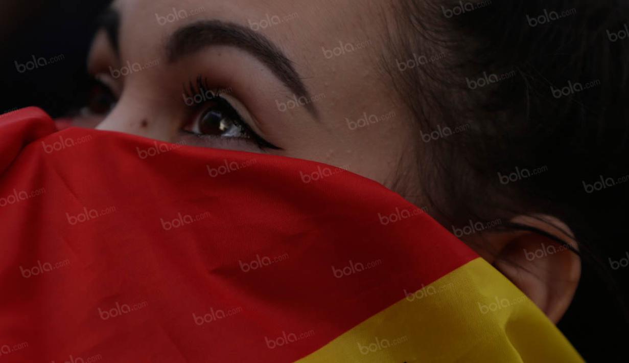 Tersingkirnya La Furia Roja dari Piala Eropa membuat para fans Spanyol bersedih, termasuk wanita ini yang menutupi wajahnya dengan bendera. (Bola.com/Vitalis Yogi Trisna)
