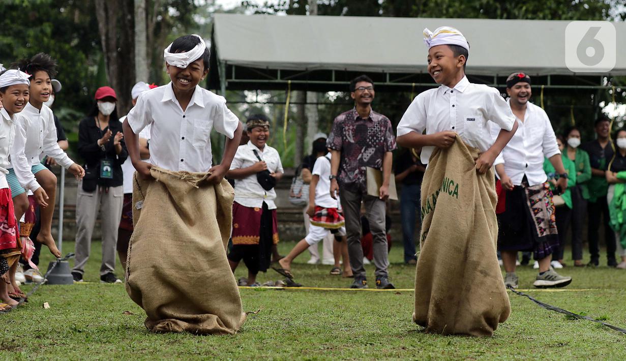 Anak-anak bersemangat mengikuti lomba balap karung usai mengikuti upacara peringatan detik-detik Proklamasi di halaman Tugu Pahlawan Banjar Penglipuran, Kabupaten Bangli, Bali, Kamis (17/8/2023). (Liputan6.com/Helmi Fithriansyah)