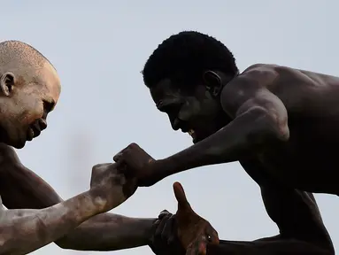 Dua pegulat bertarung sengit dalam Kompetisi Gulat Nasional Sudan Selatan di Stadion Juba, Sudan (20/4). Kompetisi gulat ini diselenggarakan dalam rangka untuk perdamaian. (CARL DE SOUZA / AFP)