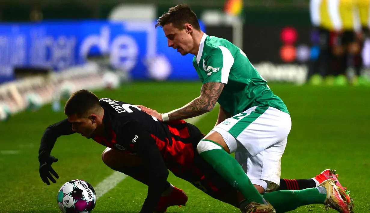 Striker Eintracht Frankfurt, Andre Silva (kiri) dan striker Werder Bremen, Marco Friedl terjatuh usai perebutan bola dalam laga lanjutan Liga Jerman 2020/21 pekan ke-23 di Weserstadion, Bremen, Jumat (26/2/2021). Eintracht Frankfurt kalah 1-2 dari Werder Bremen. (AFP/Patrik Stollarz/Pool)