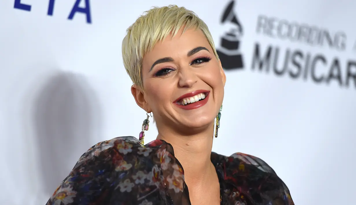 Penyanyi Katy Perry tersenyum saat berpose menghadiri pesta Gala Musicares Person of The Year 2019 di Los Angeles (8/2). Katy Perry tampil menawan mengenakan gaun hitam bermotif kembang dengan belahan hingga paha terbuka. (AP Photo/Jordan Strauss)