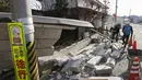 Pria membantu membersihkan puing-puing setelah dinding rumah runtuh di kota Kunimi, utara kota Fukushima, timur laut Jepang, Minggu (14/2/2021).  Gempa bumi berkekuatan 7,1 magnitudo mengguncang prefektur Fukushima, Jepang, pada Sabtu (13/2/2021) malam. (Jun HIrata/Kyodo News via AP)