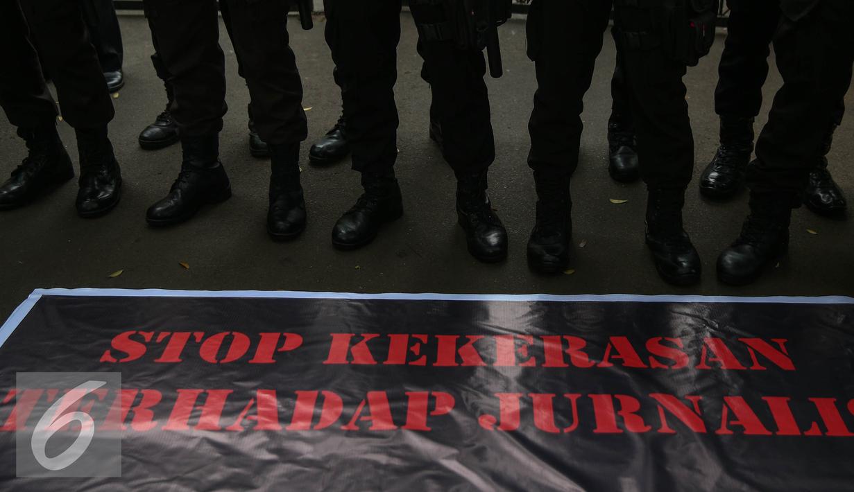 Spanduk pampang saat menggelar aksi solidaritas terhadap korban pemukulan jurnalis oleh oknum TNI AU yang terjadi di Medan, di depan Kantor Menkopolhukam, Jakarta, (25/8). (Liputan6.com/Faizal Fanani)