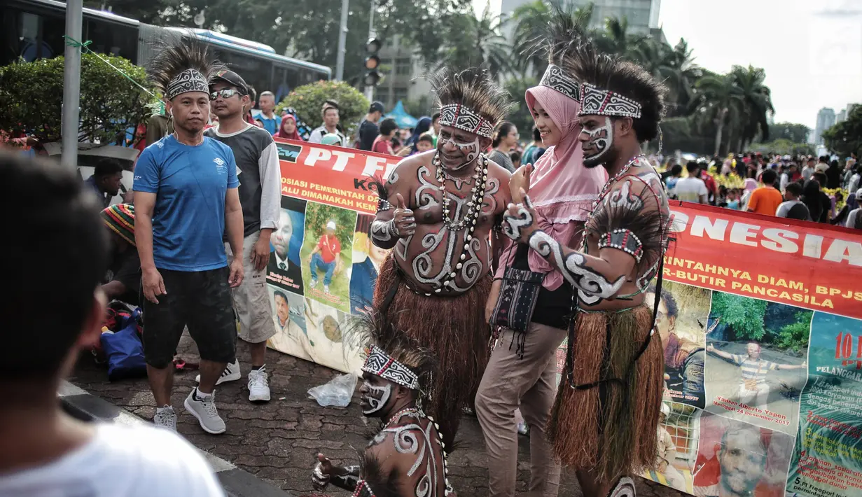 Masyarakat foto bersama eks pekerja PT Freeport Indonesia saat Car Free Day di kawasan Bunderan HI, Jakarta, Minggu (30/12). Aksi tersebut dilakukan protes mereka ke pemerintah. (Liputan6.com/Faizal Fanani)