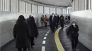 Orang-orang yang mengenakan masker pelindung untuk membantu mengekang penyebaran virus corona berjalan di sepanjang jalan bawah tanah (26/1/2021). Jepang mengonfirmasi lebih dari 1.000 kasus Virus Corona baru pada 26 Januari 2021. (AP Photo/Eugene Hoshiko)