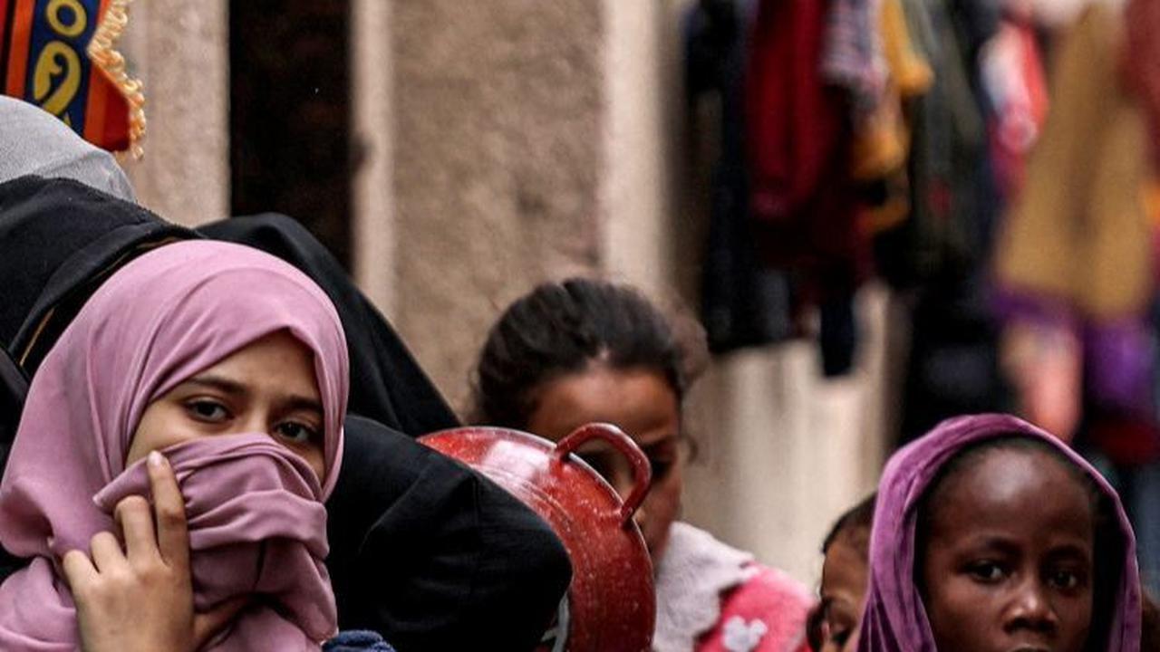 Untuk mendapatkan makanan, mereka harus mengantre panjang. Foto: SAID KHATIB / AFP<br>