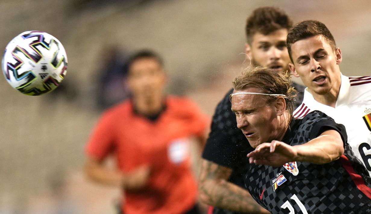 Bek Kroasia, Domagoj Vida (depan) mengontrol bola dibayangi striker Belgia, Thorgan Hazard dalam laga uji coba menjelang berlangsungnya Euro 2020 di King Baudouin Stadium, Brussels, Minggu (6/6/2021). Kroasia kalah 0-1 dari Belgia. (AP/Francisco Seco)