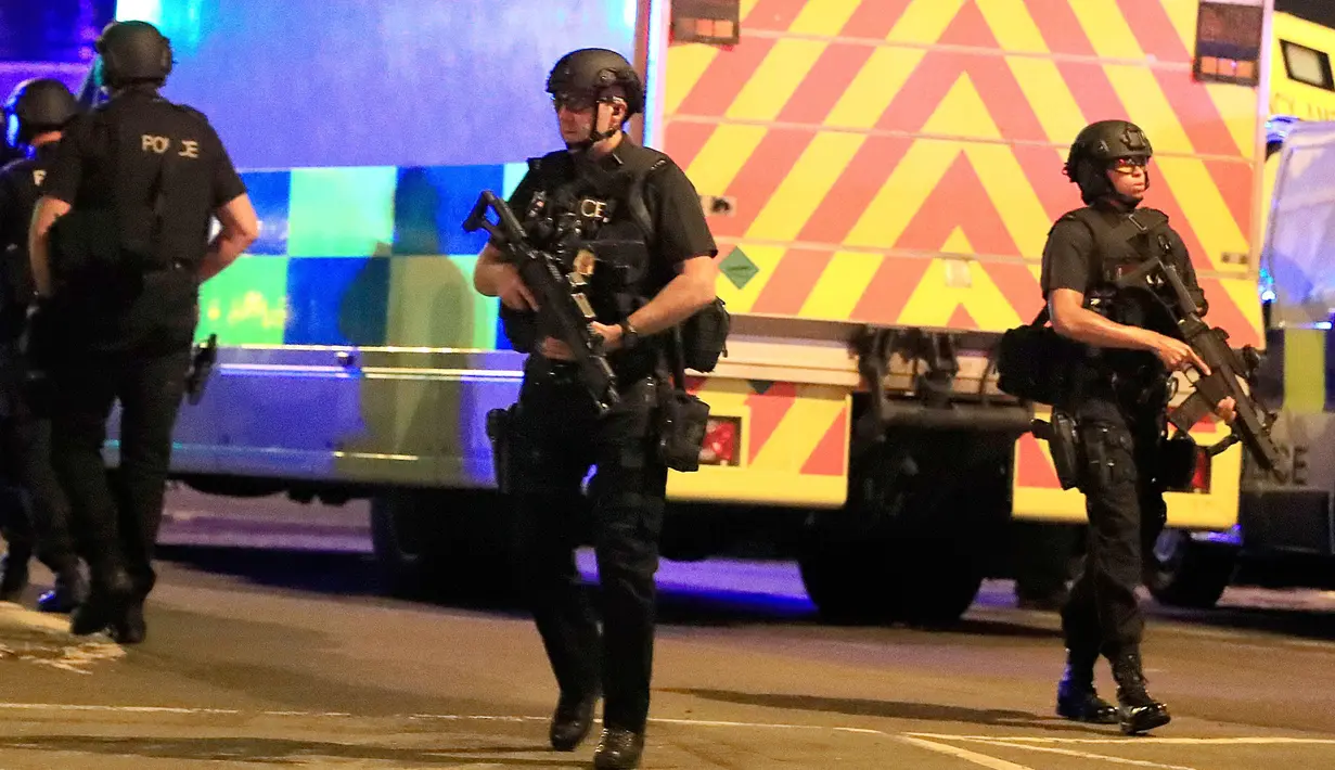 Polisi bersenjata mengamankan lokasi terjadinya ledakan usai konser penyanyi Ariana Grande di Manchester Arena, Inggris, Senin (22/5). Ledakan mengakibatkan stasiun kereta Manchester Victoria yang tak jauh dari lokasi ditutup. (Peter Byrne/PA via AP)