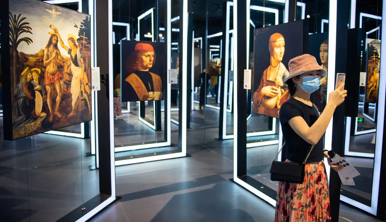 Seorang pengunjung mengabadikan gambar dalam sebuah pameran seni bertajuk Tribute to da Vinci yang digelar di gedung Changsha IFS, Changsha, Provinsi Hunan, China, Senin (4/5/2020). (Xinhua/Chen Sihan)