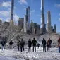 Orang-orang berdiri di viewpoint Central Park setelah badai salju pertama musim dingin 2022 di New York City, Jumat (7/1/2022). Badai musim dingin membawa lebih dari 15 cm salju di bagian timur Amerika Serikat (AS), menutup sekolah, kantor dan jalan-jalan. (Ed JONES / AFP)