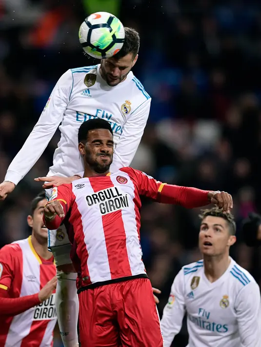 Bek Real Madrid Nacho Fernandez berebut bola dengan pemain belakang Girona, Jonas Ramalho saat pertandingan La Liga Spanyol di stadion Santiago Bernabeu di Madrid (18/3). (AFP Photo / Javier Sorioano)