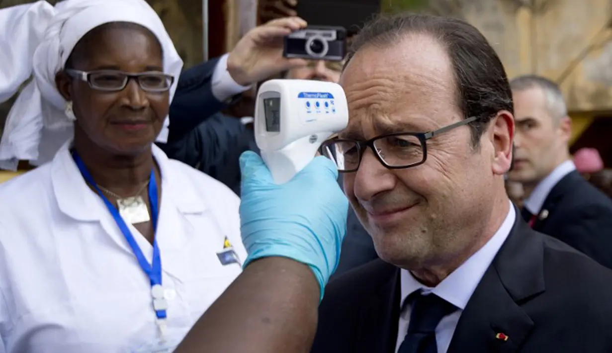 Presiden Prancis Francois Hollande diperiksa suhunya saat mengunjungi rumah sakit Donka, Guinea, 28 November 2014. Francois menjadi pimpinan Barat pertama yang mengunjungi negara yang terkena dampak terparah dari Ebola. (AFP PHOTO/ POOL/ALAIN JOCARD)
