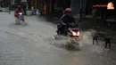 Sejumlah pengendara motor tampak nekat menerobos banjir yang menggenangi jalan di wilayah Karang Dinoyo (Liputan6.com/Helmi Fithriansyah).