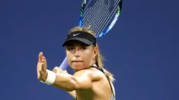 Petenis Rusia, Maria Sharapova mengembalikan bola Patty Schnyder dari Swiss pada pertandingan tunggal pertama putri AS Terbuka 2018 di New York, (28/8). Sharapova menang dua set langsung 6-2, 7-6 (6). (AFP Photo/Julian Finney)