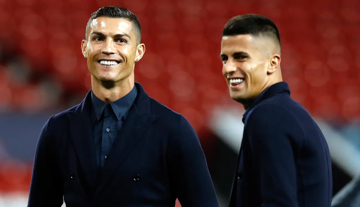 Cristiano Ronaldo tersenyum saat berada di stadion Old Trafford, Manchester, Inggris (22/10). Ronaldo tampil keren mengenakan setelan jas dengan sepatu putih saat mengunjungi stadion bekas klub lamanya tersebut. (AP Photo/Martin Rickett)