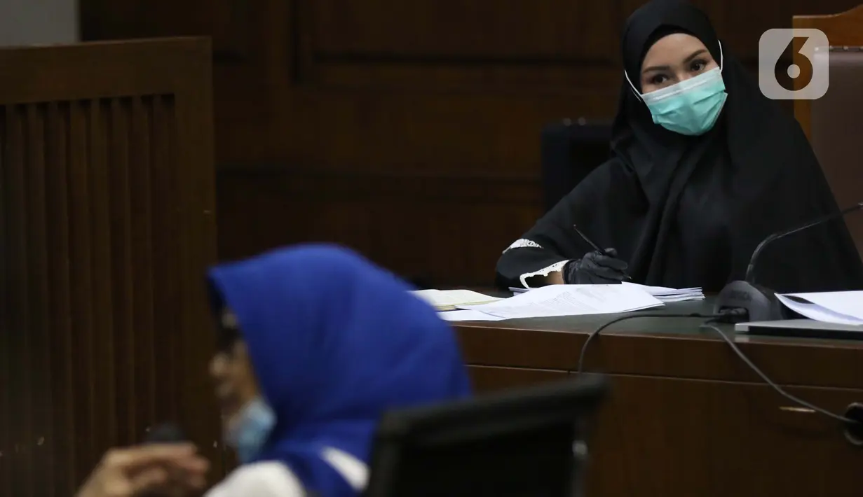 Terdakwa dugaan suap dan tindak pidana pencucian uang terkait pengurusan fatwa Mahkamah Agung, Pinangki Sirna Malasari menyimak kesaksian mantan kuasa hukum Djoko S Tjandra Anita Kolopaking saat sidang lanjutan di Pengadilan Tipikor Jakarta, Rabu (25/11/2020). (Liputan6.com/Helmi Fithriansyah)