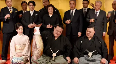 Pegulat sumo Jepang, Kisenosato foto bersama saat mendapat hidangan ikan red sea bream merayakan kemenangannya dalam upacara yang berlangsung di Tokyo, Jepang, Rabu (25/1). (AFP Photo/Toru Yamanaka) 