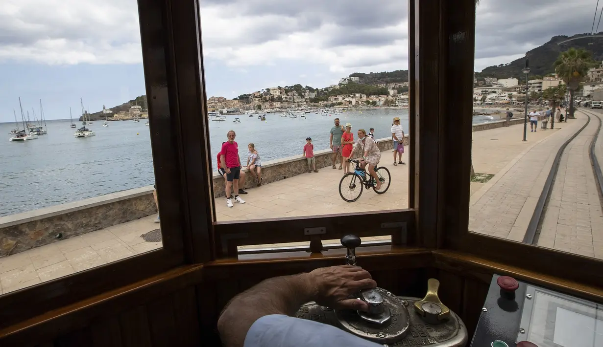 Pengemudi trem Soller-Puerto de Soller tiba di Puerto de Soller di Pulau Balearic Spanyol Mallorca (14/7/2021). Diresmikan pada tahun 1912, jalur kereta api Palma-Soller adalah salah satu rute tertua yang masih beroperasi di Spanyol. (AFP/Jaime Reina)