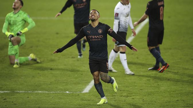 Penyerang Manchester City, Gabriel Jesus berselebras usai mencetak gol ke gawang Swansea City pada laga perdelapan final Piala FA di di Liberty Stadium di Swansea, Wales, Kamis (11/2/2021). City menang atas Swansea 3-1. (Nick Potts/PA via AP)