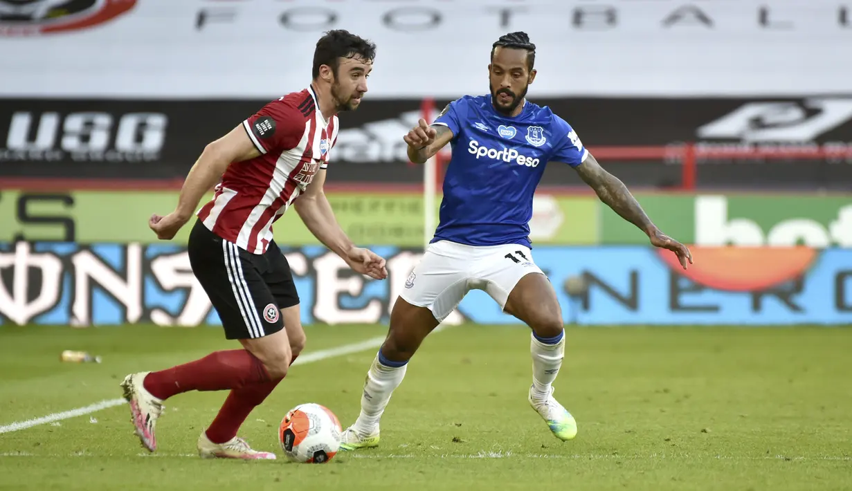 Pemain Sheffield United Enda Stevens (kiri) menggiring bola mencoba melewati pemain Everton Theo Walcott pada pertandingan Premier League di Bramall Lane, Sheffield, Inggris, Senin (20/7/2020). Everton menang 1-0. (AP Photo/Rui Vieira, Pool)