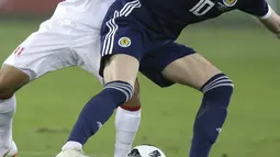 Pemain Peru, Yoshimar Yotun (kiri) berebut bola dengan pemain Skotlandia, Scott Mc Tominay pada laga uji coba di Lima, Peru, (29/5/2018). Peru menang 2-0. (AP/Martin Mejia)