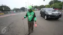 Pengendara Gojek bernama Ari mencari ranjau paku yang berserakan di sekitar Istana Negara, Jakarta, Minggu (14/8). Pria 32 tahun tersebut secara ikhlas mengumpulkan ranjau paku di sekitar Istana Negara.(Liputan6.com/Immanuel Antonius)