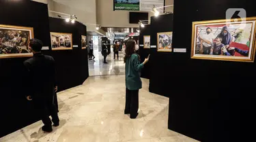 Pengunjung melihat karya foto dalam Pameran Foto Jurnalistik Warna-Warni Parlemen dengan tema Bangkit Lebih Cepat di loby Nusantara II DPR, Senayan, Jakarta, Senin (29/8/2022). Pameran ini sebagai bentuk apresiasi terhadap karya-karya  jurnalistik wartawan foto yang melaksanakan tugas di parlemen. (Liputan6.com/Johan Tallo)