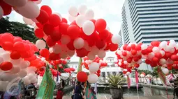 Balon merah putih menghiasi halaman Balai Kota DKI Jakarta, Senin (8/5). Balon tersebut dibawa oleh komunitas Perempuan Peduli Kota Jakarta (PPKJ) dan disebar di seluruh area halaman Balai Kota bercampur dengan karangan bunga. (Liputan6.com/Faizal Fanani)