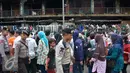 Petugas kepolisian berjaga di sekitar tempat perdagangan di depan gedung Pasar Senen pasca kebakaran, Jakarta, Minggu (22/1). (Liputan6.com/Helmi Affandi)